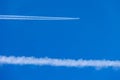 Condensation trace highlighted by the setting sun behind a twin-engine turbojet passenger plane in the March sky.