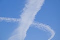 Condensation trails crossing, Chemtrail against the blue sky.