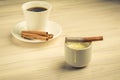 Condensed milk with cinnamon and a white cup with coffee/condensed milk with cinnamon and a white cup with coffee. selective focus