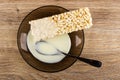 Condensed milk poured on puffed rice, spoon in brown saucer on wooden table. Top view Royalty Free Stock Photo