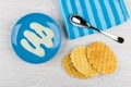 Condensed milk and spoon on wafer cookie in blue saucer Royalty Free Stock Photo