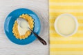 Condensed milk, teaspoon, wafer cookies with milk in blue saucer Royalty Free Stock Photo