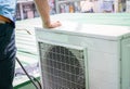 Condensing unit of an air conditioner on blur technician spraying water. Air conditioner cleaning by a man. Air conditioner