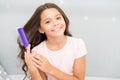 Conditioner or mask organic oil comb hair. Beauty salon tips. Girl long curly hair grey interior background. Child curly