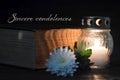 Condolence card with memorial candle, white flower and book. Sincere condolences