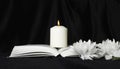 Condolence card. A white memorial candle with white flowers and an open book. The funeral, the sadness Royalty Free Stock Photo