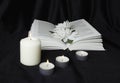 Condolence card. A white memorial candle with white flowers and an open book. The funeral, the sadness Royalty Free Stock Photo