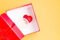 condom and smiling heart in a red gift box, box cover open