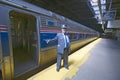 Conductor at Amtrak train platform announces All Aboard at East Coast train station on the way to New York City, New York
