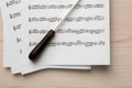 Conductor`s baton and sheet music on white wooden table, top view Royalty Free Stock Photo