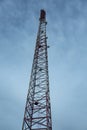 Cone-shaped metal mobile communications tower cell site against the sky at dusk. Vertical orientation. Royalty Free Stock Photo