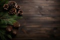 Cones and fir tree branches on dark wooden table. Christmas flat lay background with copy space