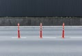 Cones with orange and white stripes standing on street on gray asphalt road. Royalty Free Stock Photo