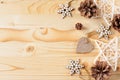 Cones, stars and wooden figures in snowflakes on a light wooden background