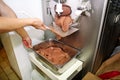 Confectioner in chef uniform is working on ice cream maker machine. Producing black chocolate ice cream flavors.