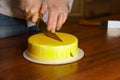 Confectioner cuts honey cake in mirrored glaze