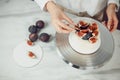 Confectioner decorates bento cake with figs