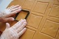 The confectioner forms gingerbread cookies using an original rectangular cutting. Woman& x27;s hands in protective gloves Royalty Free Stock Photo