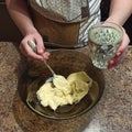 Confectioner mixing butter in bowl and hold water