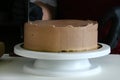 Confectioner process chocolate cake on table. The process of decorating the cake with liquid chocolate. The process of making the Royalty Free Stock Photo