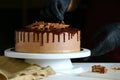Confectioner process chocolate cake on table. The process of decorating the cake with liquid chocolate. The process of making the Royalty Free Stock Photo