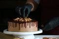 Confectioner process chocolate cake on table. The process of decorating the cake with liquid chocolate. The process of making the Royalty Free Stock Photo