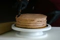 Confectioner process chocolate cake on table. The process of decorating the cake with liquid chocolate. The process of making the Royalty Free Stock Photo