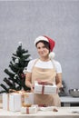 Confectioner woman in an apron holds gift box with sweets. Holidays. Vertical frame