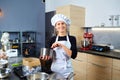 A confectioner woman with a cake in her hand in pastry shop.