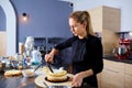 A confectioner woman makes cake in the kitchen.