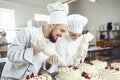 A confectioners squeezes liquid cream from a pastry bag.