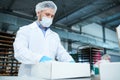 Confectionery factory employee preparing package Royalty Free Stock Photo