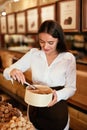 Confectionery. Woman Selling Chocolate Candies In Store