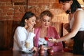 Confectionery. Women Tasting Chocolate Candy In Cafe.