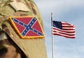 The Confederate Rebel Flag on military uniform and Flag of USA weaving in the sky. American Civil War Royalty Free Stock Photo