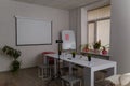 Conference hall, white bright clean office with table, chairs, projector, whiteboard, pink arm-chair and lots of potflowers Royalty Free Stock Photo