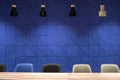 Conference room with blue wall and hanging lamps Royalty Free Stock Photo