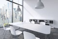 A conference room in a modern panoramic office in New York. White table, white chairs, two white ceiling lights and a bookcase. Royalty Free Stock Photo