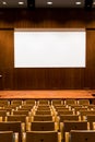 Conference room with wooden seating, stage and large cinema screen in auditorium. Wooden room for conferences and shows, cinema Royalty Free Stock Photo