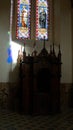 Confessional below a stained glass window in a church Royalty Free Stock Photo