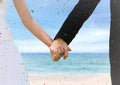 Confetti and bride and groom holding hands at blurry beach Royalty Free Stock Photo