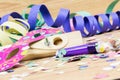 Confetti, streamers, mask and party blower on wood background Royalty Free Stock Photo