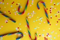 Confetti texture and candy cane lie on a yellow background Royalty Free Stock Photo