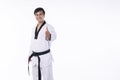 Confidence athlete strong young man wear uniform taekwondo with black belt showing thumbs up while standing over isolated white