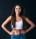 Confidence boosts beauty. Studio portrait of an attractive young woman posing against a dark background. Royalty Free Stock Photo