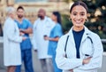 Confidence, crossed arms and portrait of a female doctor with her team outdoor at the hospital. Leadership, smile and Royalty Free Stock Photo