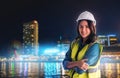 Confidence Civil Engineer with safety equipment with night modern city in the background for City Development cocept