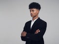 The confidence to suit his ambition. Studio shot of a young businessman looking away thoughtfully against a grey Royalty Free Stock Photo