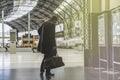 Confident adult man standing with travel bag at the hall of railway station and looking train schedule.Visual effects. Royalty Free Stock Photo