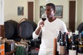 Confident african american male winemaker inspecting quality of